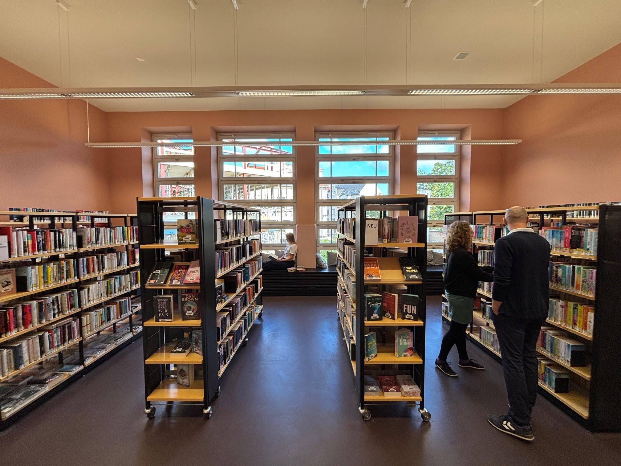 Bibliotheksregale und 3 Personen