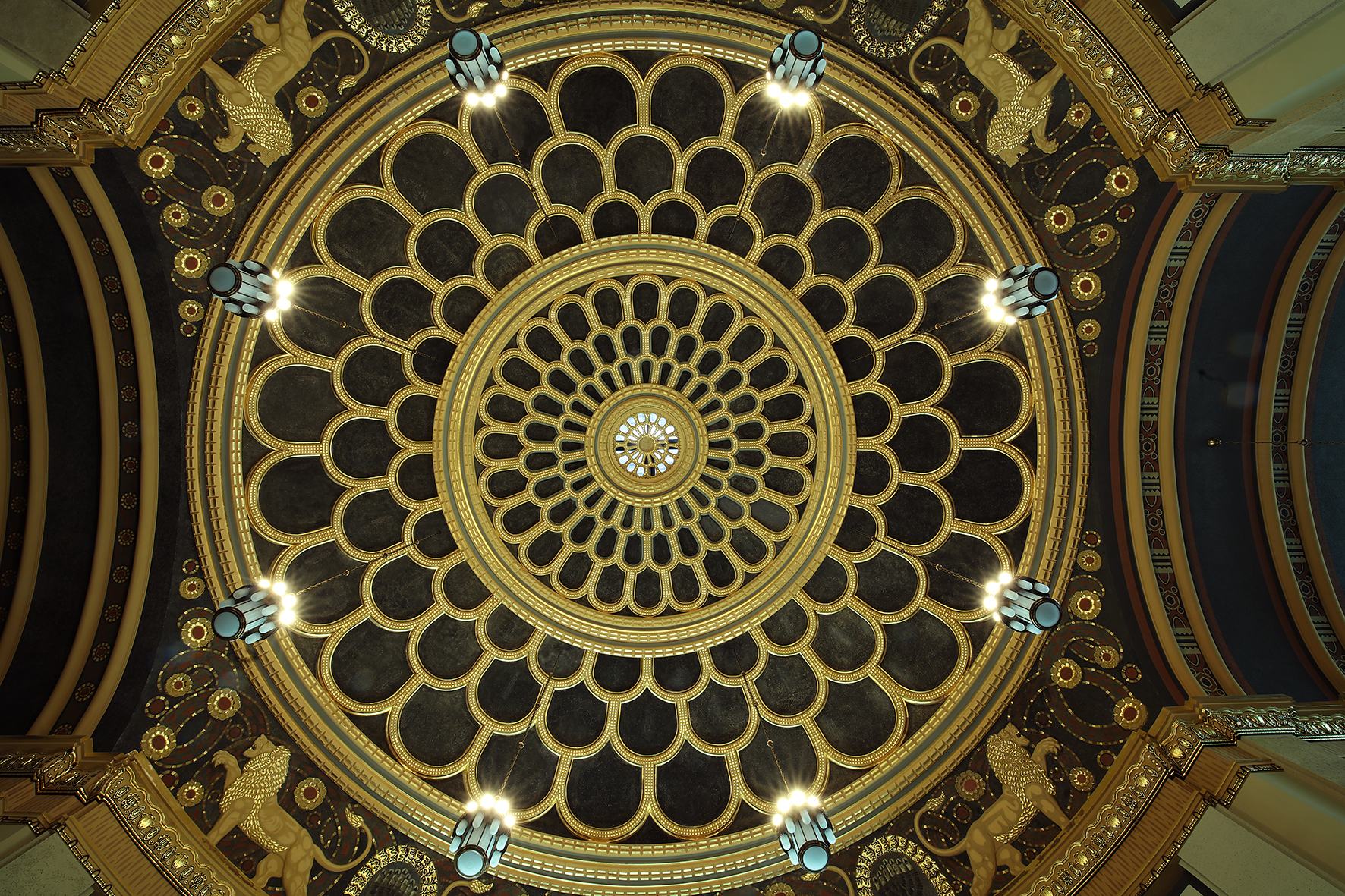 Eine goldverzierte Kuppel mit acht Leuchtern