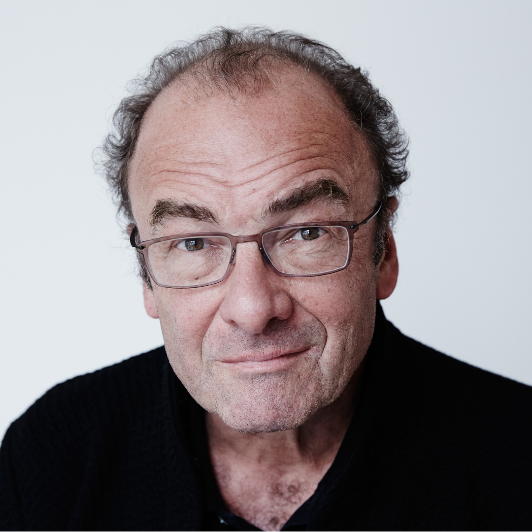 älterer Mann mit dunklen, kurzen Haaren und einer Brille