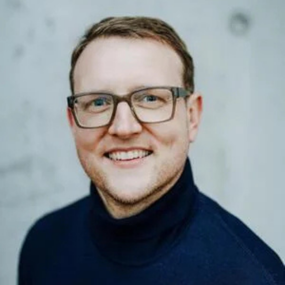 junger Mann mit blauem Oberteil und Brille