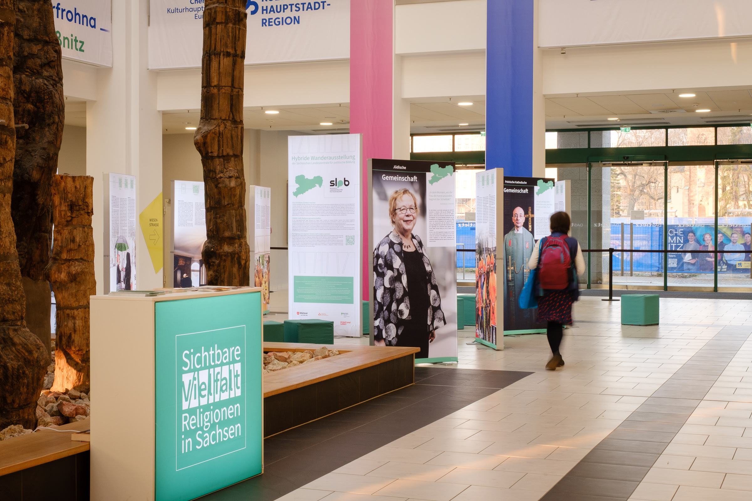 Ein Blick in die Ausstellung im Tietz in Chemnitz. Man sieht mehrere Ausstellungstafeln, auf denen u.a. die Vorsitzende der Jüdischen Gemeinde Chemnitz, Dr. Ruth Röcher, zu sehen ist.